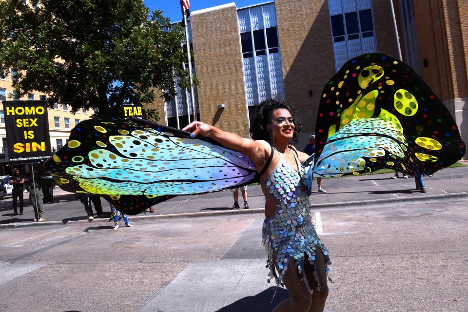 Carlos Martinez, who performs under the name "Jayca," twirls in front of a group protesting Saturday's Pride Parade on Pine Street. It was Abilene's first parade celebrating the LGBTQ+ community.