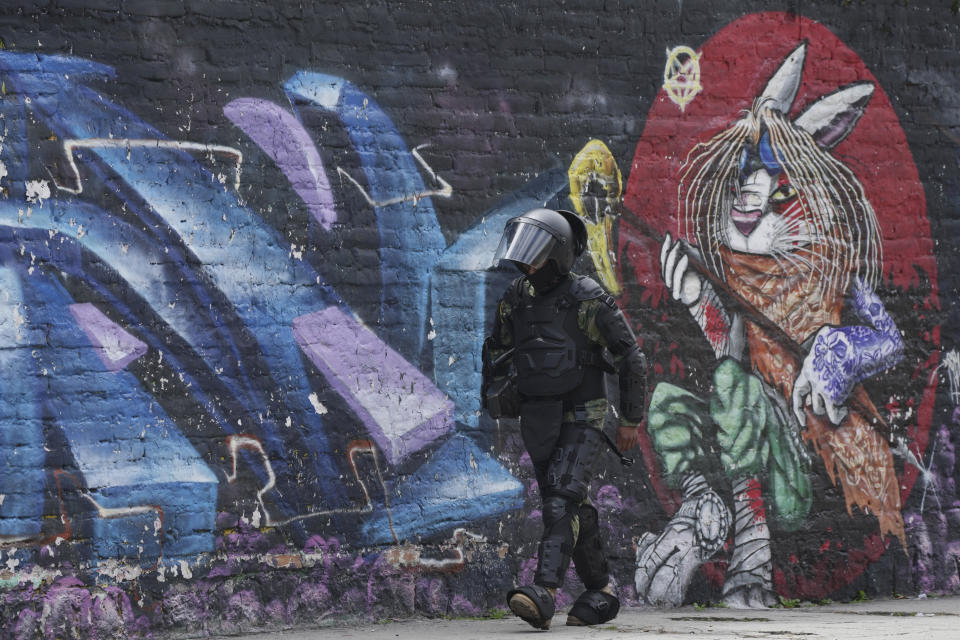 A soldier walks past a mural near the National Assembly the day after the body was disolved by President Guillermo Lasso in Quito, Ecuador, Thursday, May 18, 2023. Lawmakers were moving forward with impeachment proceedings against the president on embezzlement charges when he disolved it, and now residents are expected to elect a new president and a new lawmakers in no more than 90 days. (AP Photo/Dolores Ochoa)