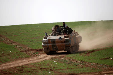 Rebel fighters ride a military vehicle east of al-Bab town, Syria March 9, 2017. REUTERS/Khalil Ashawi