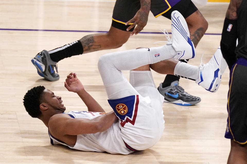 Denver Nuggets guard PJ Dozier writhes on the ground after being injured during the second half of an NBA basketball game against the Los Angeles Lakers Monday, May 3, 2021, in Los Angeles. (AP Photo/Mark J. Terrill)