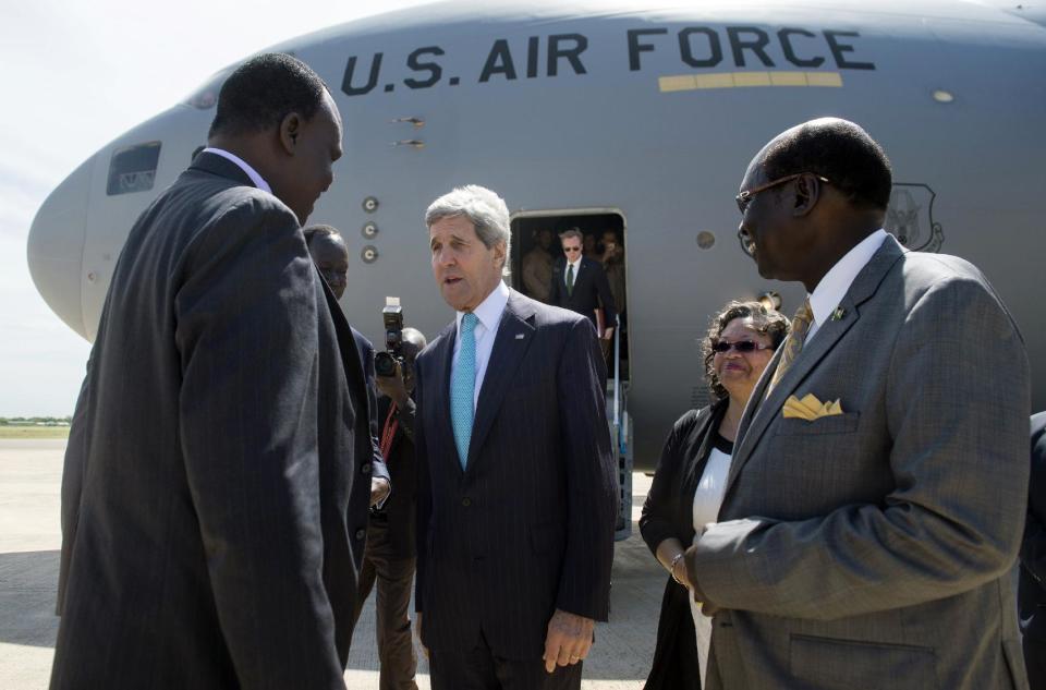 U.S. Secretary of State John Kerry, center, is greeted by officials upon his arrival aboard a U.S. military airplane at Juba International Airport in Juba, South Sudan, Friday, May 2, 2014. Kerry is urging South Sudan's warring government and rebel leaders to uphold a monthslong promise to embrace a cease-fire or risk the specter of genocide through continued ethnic killings. (AP Photo/Saul Loeb, Pool)