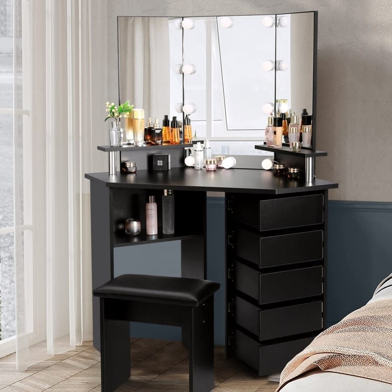 black vanity with mirror, matching seat, and five drawers