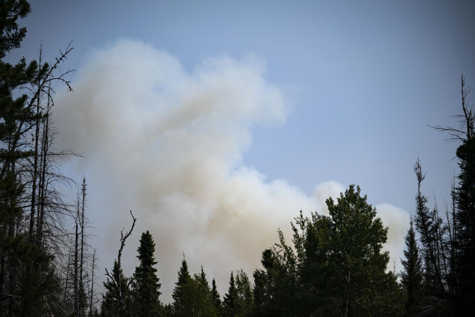 Smoke rises above the Superior National Forest as the Greenwood Fire burns through towards Highway 2 towards the northeast on Monday, Aug. 16, 2021, in Duluth, Minn. The wildfire has continued to grow and spread towards the northeast as firefighters battle the flames from both the ground and air. (Alex Kormann/Star Tribune via AP)