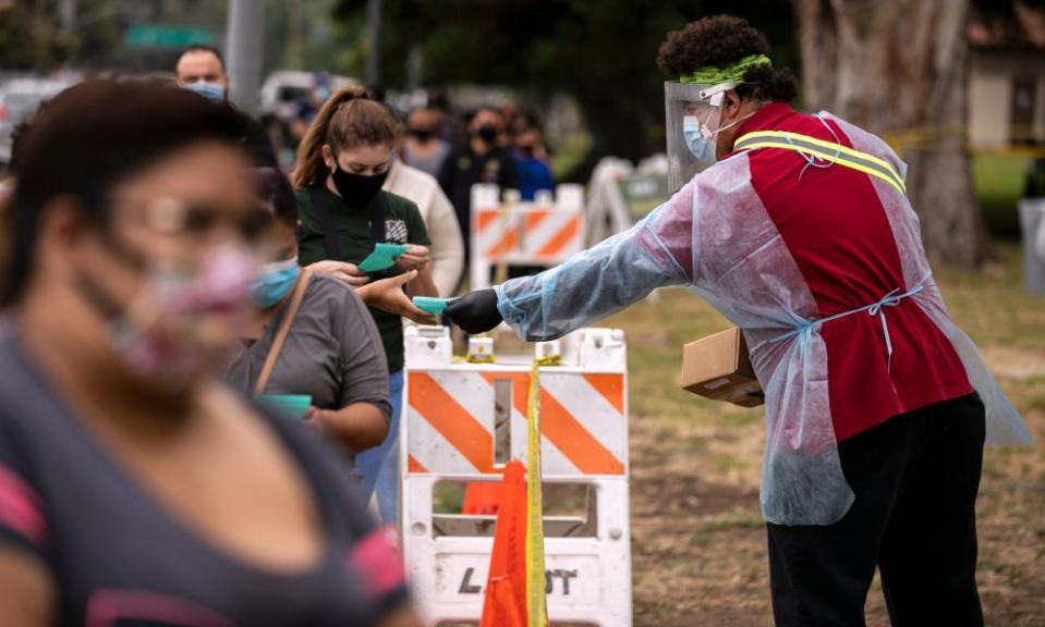 People wait in line to be tested for Covid-19 at a drive-in and walk-up testing site in Los Angeles on 1 July.