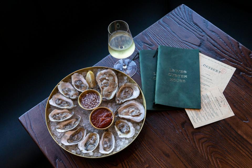 A dozen oysters and a glass of white wine rest on a table at the new restaurant Lewes Oyster House located in the historic district of downtown Lewes, Del., Tuesday, November 1, 2022.