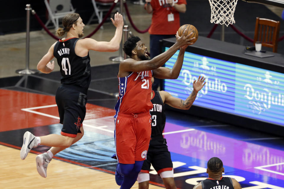 Philadelphia 76ers center Joel Embiid (21) gets a shot up past Houston Rockets forward Kelly Olynyk (41) and guard Kevin Porter Jr., right, during the second half of an NBA basketball game Wednesday, May 5, 2021, in Houston. (AP Photo/Michael Wyke, Pool)