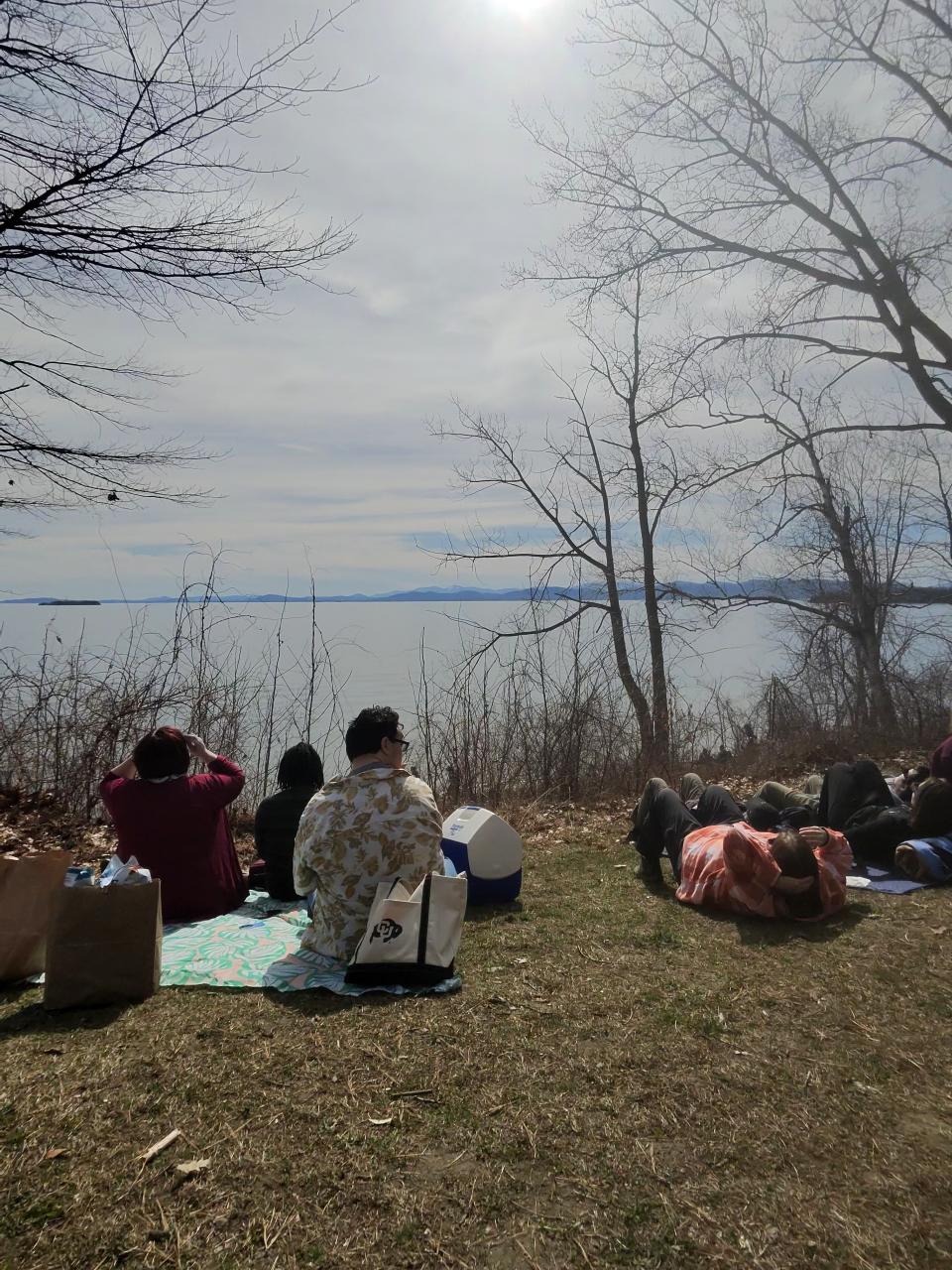 People watching the total solar eclipse on the shore of Lake Champlain Vermont