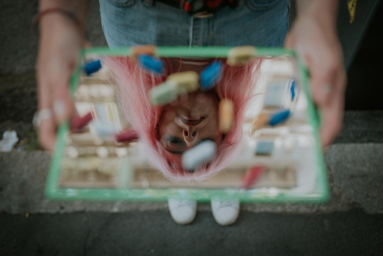 A woman holding a tray of pills