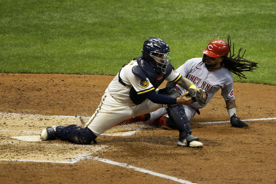 Cincinnati Reds' Freddy Galvis, right, is forced out by Milwaukee Brewers' Omar Narvaez during the fifth inning of a baseball game Tuesday, Aug. 25, 2020, in Milwaukee. (AP Photo/Aaron Gash)