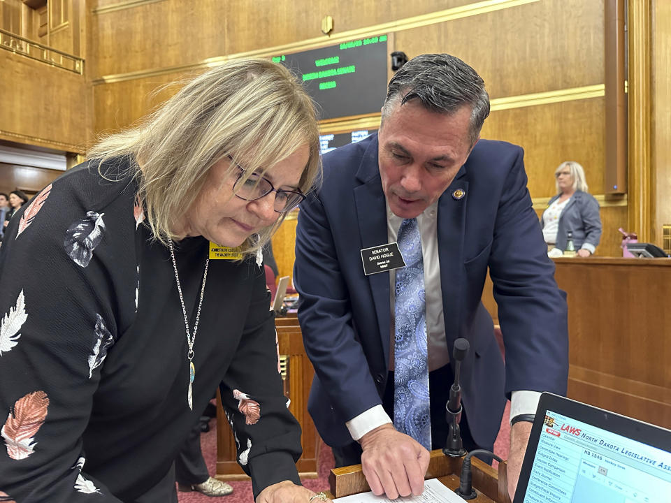 North Dakota Senate Republican Majority Leader David Hogue, right, and Administrative Assistant Renae Doan, left, confer before final Senate votes at the state Capitol in Bismarck, N.D., on Wednesday, Oct. 25, 2023. The Republican-controlled Legislature adjourned and ended a three-day special session to fix a budget mess after the state Supreme Court voided a major budget bill last month. (AP Photo/Jack Dura)