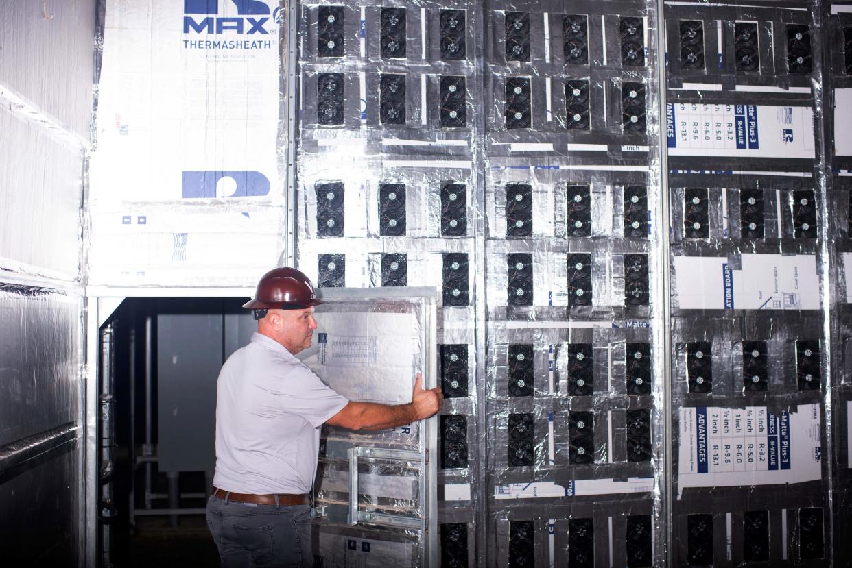 Whinstone CEO Chad Harris walks into a room with Bitcoin mining machines at the Whinstone US Bitcoin mining facility in Rockdale, Texas, on October 10, 2021. - The long sheds at North America's largest bitcoin mine look endless in the Texas sun, packed with the type of machines that have helped the US to become the new global hub for the digital currency. The operation in the quiet town of Rockdale was part of an already bustling US business -- now boosted by Beijing's intensified crypto crackdown that has pushed the industry west. Experts say rule of law and cheap electricity in the US are a draw for bitcoin miners, whose energy-gulping computers race to unlock units of the currency. 