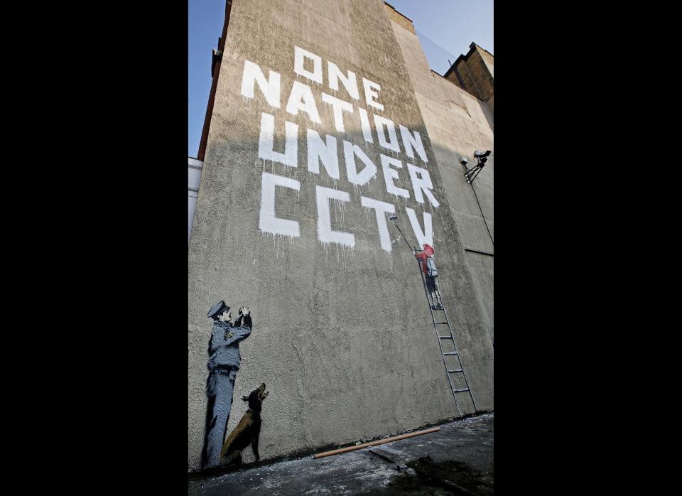 LONDON - APRIL 14:  A new Banksy graffiti work on a private property catches the eye of passers by on April 14, 2008 in London, England. The work, which depicts a child painting the words 'One Nation Under CCTV' with a security guard watching him is situated under a security camera and has appeared sometime between the hours of Saturday and Monday morning.  (Photo by Cate Gillon/Getty Images)