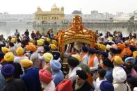 Devotees carry the Sikh holy book during a procession in Amritsar