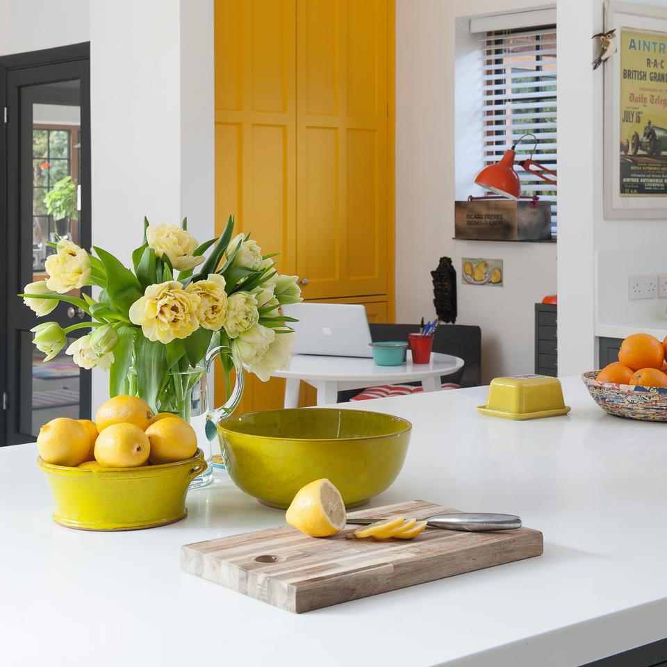 Kitchen island with bowl of lemons and vase of flowers