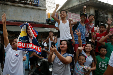 Supporters watch the motorcade of presidential candidate Rodrigo "Digong" Duterte (not pictured) during election campaigning in Malabon, Metro Manila in the Philippines April 27, 2016. REUTERS/Erik De Castro