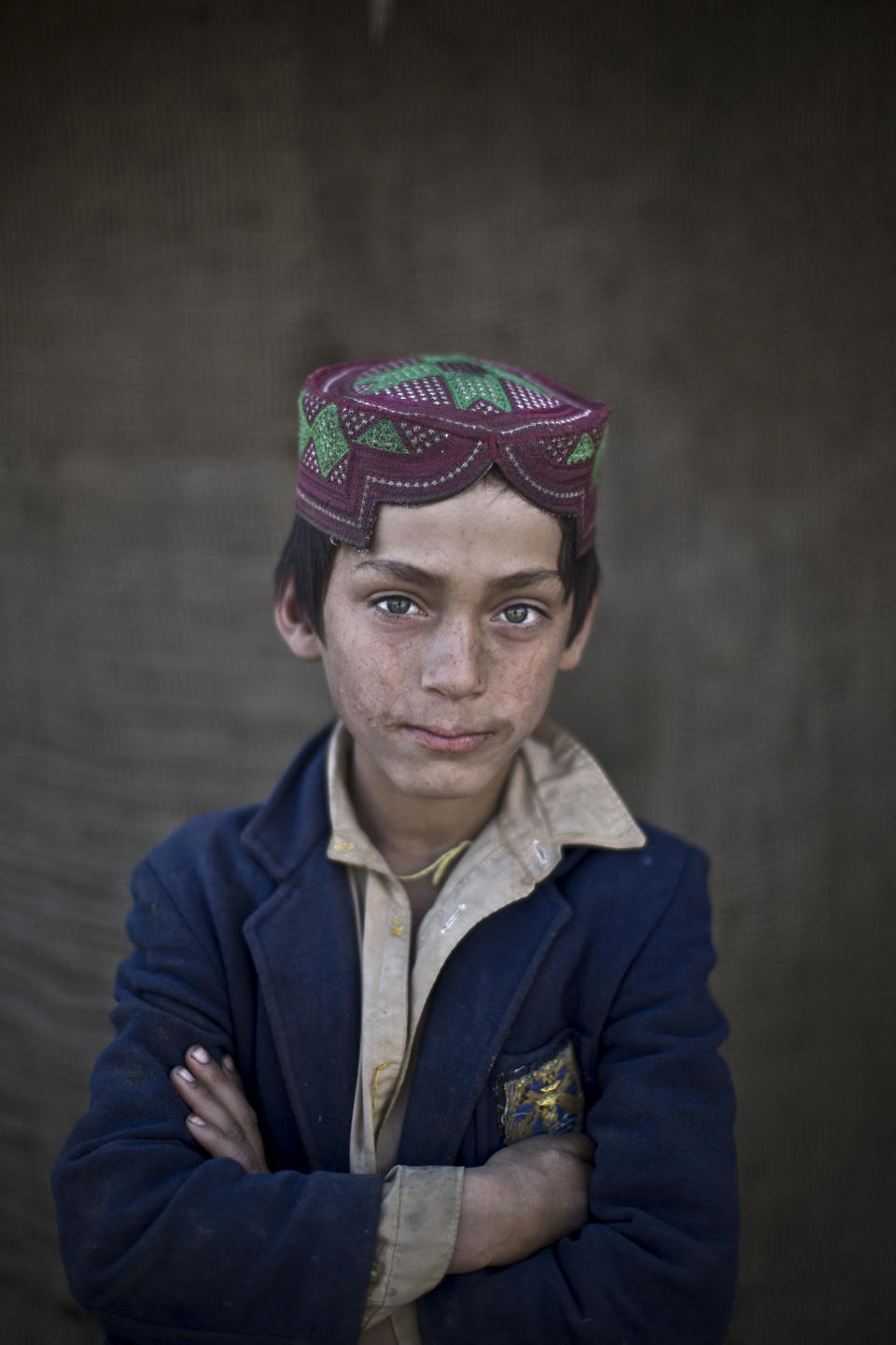 In this Sunday, Jan. 26, 2014 photo, Afghan refugee boy, Ibraheem Rahees, 8, poses for a picture, in a slum on the outskirts of Islamabad, Pakistan. For more than three decades, Pakistan has been home to one of the world’s largest refugee communities: hundreds of thousands of Afghans who have fled the repeated wars and fighting their country has undergone. Since the 2002 U.S.-led invasion of Afghanistan, some 3.8 million Afghans have returned to their home country, according to the U.N.’s refugee agency. (AP Photo/Muhammed Muheisen)