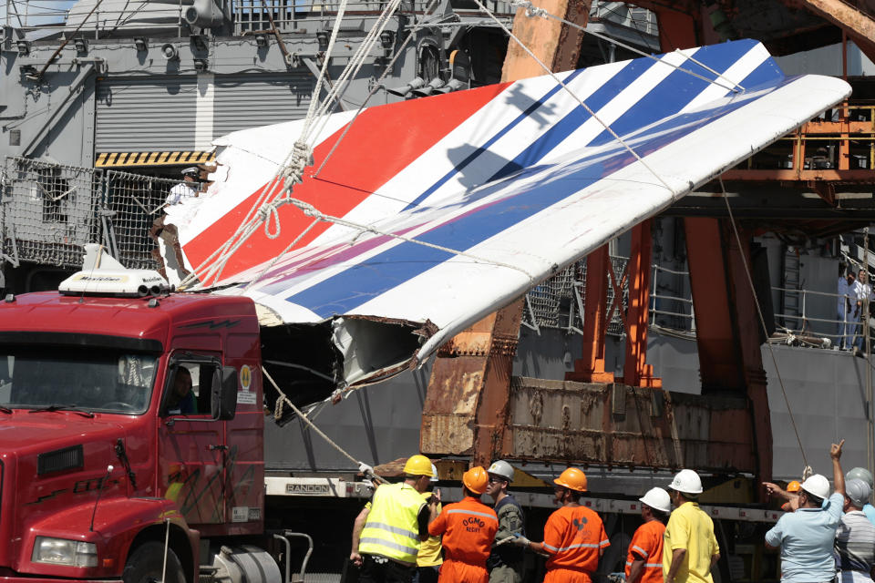 FILE - Workers unloading debris, belonging to crashed Air France flight AF447, from the Brazilian Navy's Constitution Frigate in the port of Recife, northeast of Brazil, Sunday, June 14, 2009. A French court is ruling Monday April 17, 2023 on whether Airbus and Air France are guilty of manslaughter over the 2009 crash of Flight 447 en route from Rio to Paris, which killed 228 people and led to lasting changes in aircraft safety measures. (AP Photo/Eraldo Peres, File)