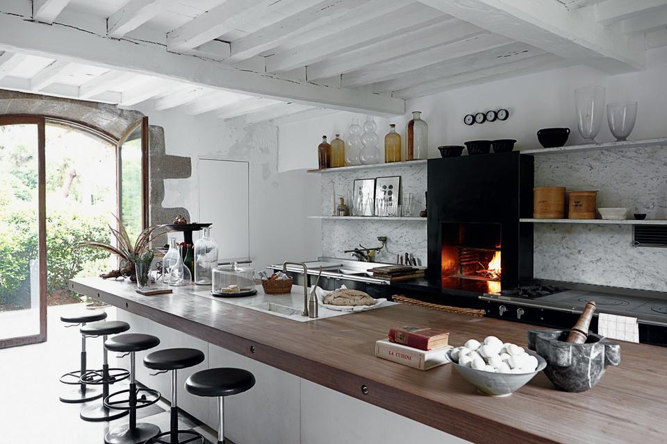 This rustic kitchen features a wood-burning oven and an island with a hardwood countertop.