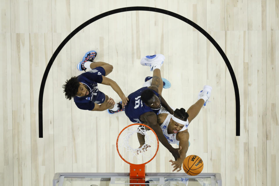 North Carolina's Armando Bacot, right, tries to get a shot past St. Peter's Fousseyni Drame, center, and Isiah Dasher during the first half of a college basketball game in the Elite 8 round of the NCAA tournament, Sunday, March 27, 2022, in Philadelphia. (AP Photo/Matt Rourke)