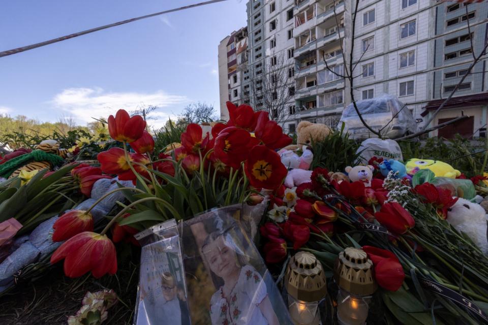 烏克蘭中部城鎮烏曼28日遭俄軍空襲，至少23人喪生，當地居民29日到災情慘重的一棟大樓前獻花哀悼。路透社