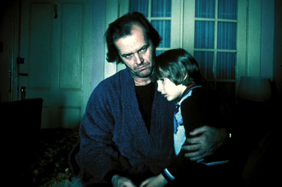 Jack Nicholson sits with a young Danny Lloyd on his lap