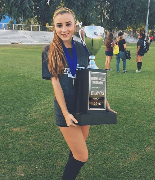 Jessica sostiene un trofeo futbolístico