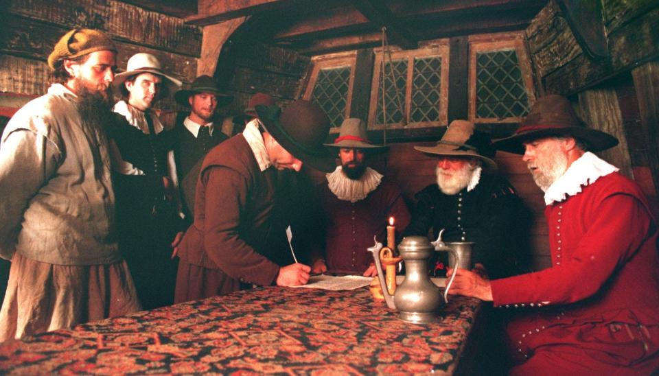 Actors recreate the signing of the Mayflower Compact  aboard the Mayflower II at the Provincetown waterfront on July 19, 1995.