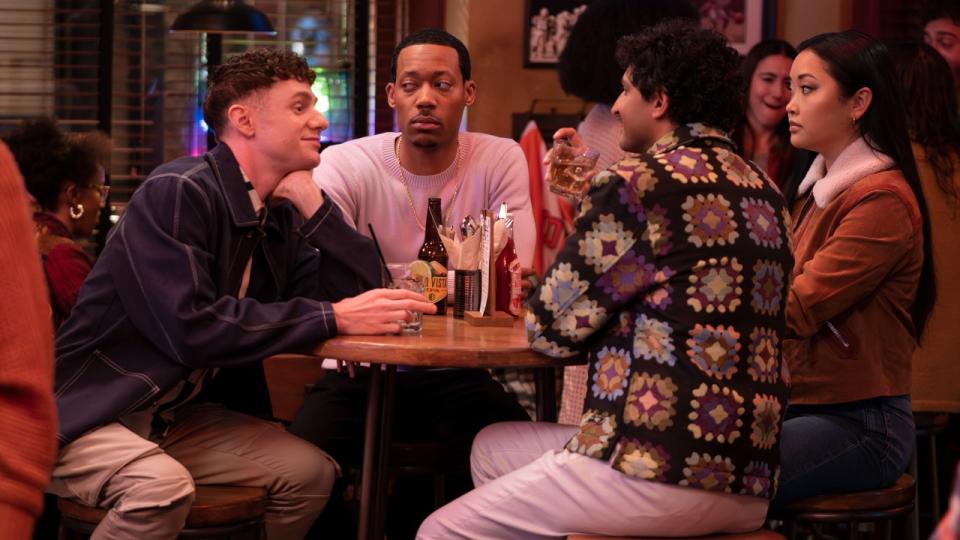 CHRIS PERFETTI, TYLER JAMES WILLIAMS, KARAN SONI, LANA CONDOR sitting around a bar table. Tyler James Williams is looking with suspecion in his eyes to his left.