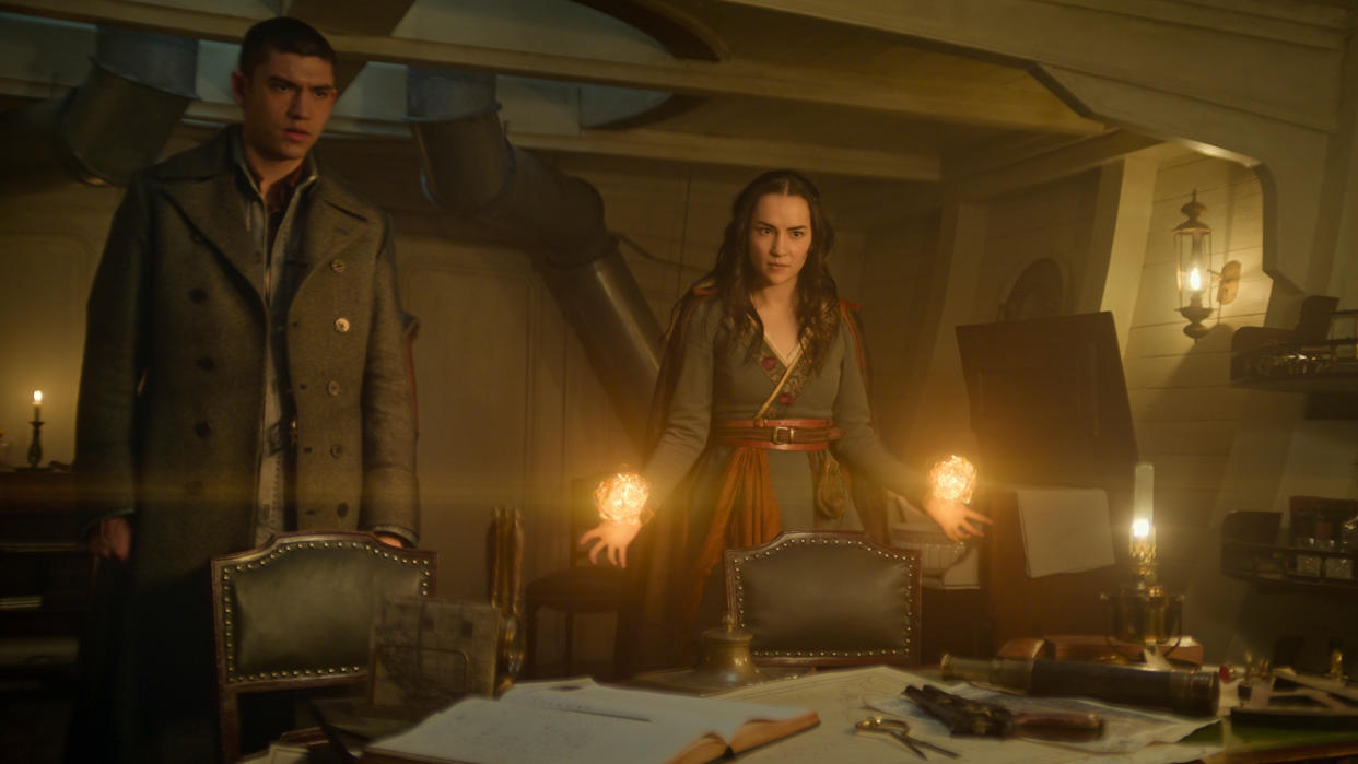  Alina (jessie Mei Li) using her powers in a ship next to Mal (Archie Renaux) in Shadow and Bone season 2. 