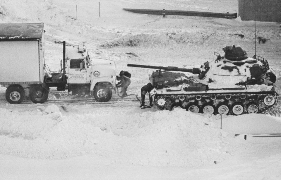 Indiana National Guardsmen use an Army tank to tow a semi-trailer truck from a snowdrift on I-65 at Ind. 32 during the Blizzard of '78.