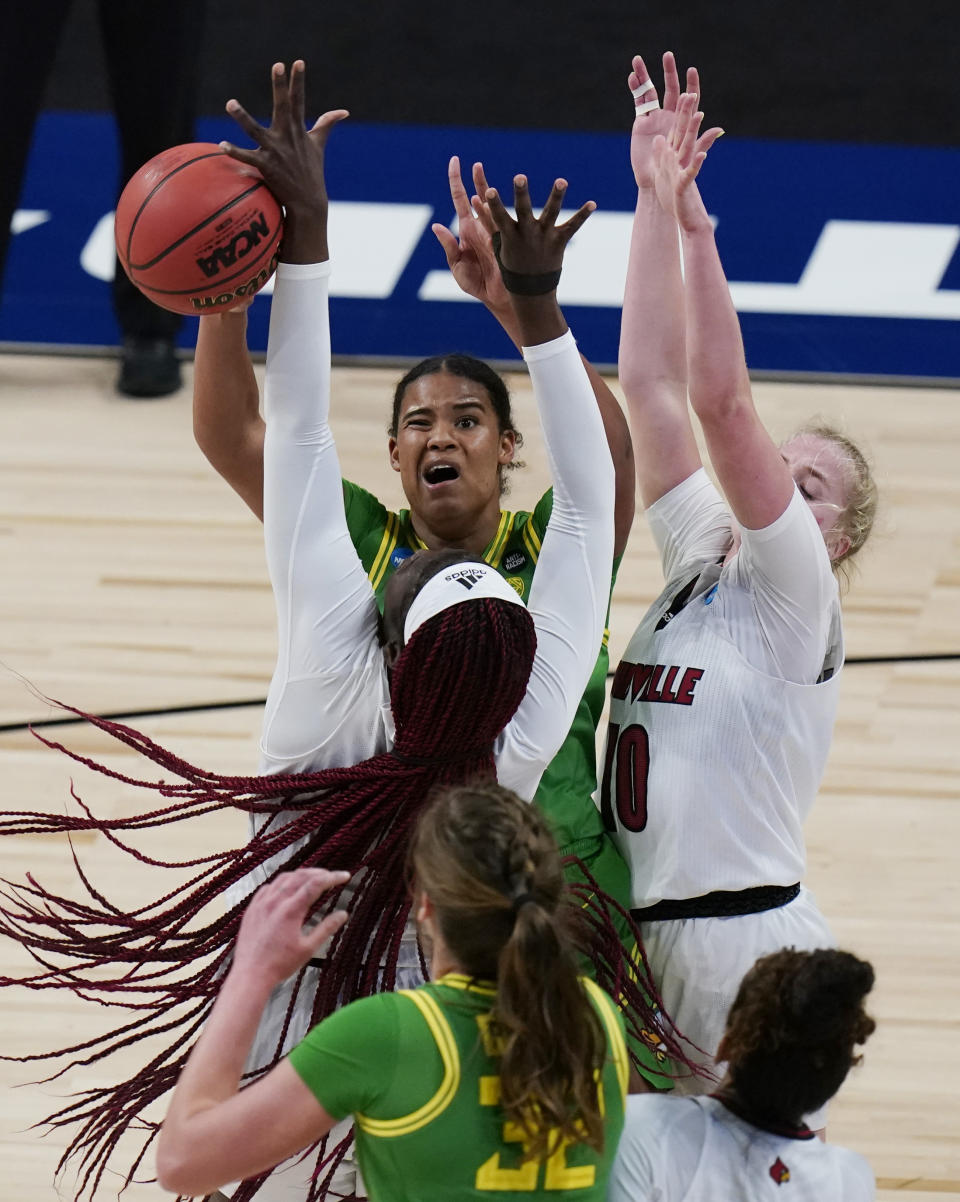 Oregon forward Nyara Sabally, center back, battles Louisville guard Hailey Van Lith (10) and Louisville forward Olivia Cochran, center, for a rebound during the second half of a college basketball game in the Sweet Sixteen round of the women's NCAA tournament at the Alamodome in San Antonio, Sunday, March 28, 2021. (AP Photo/Eric Gay)