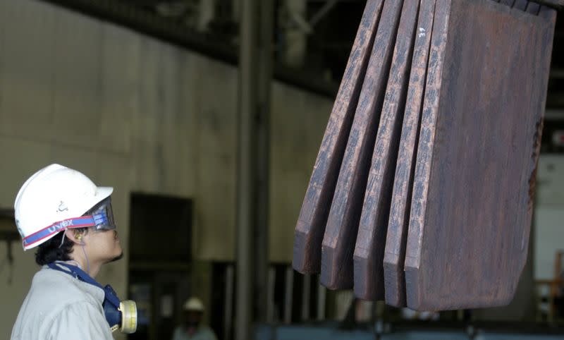 FILE PHOTO: A worker monitors the loading of copper plates at PT Smelting in Gresik