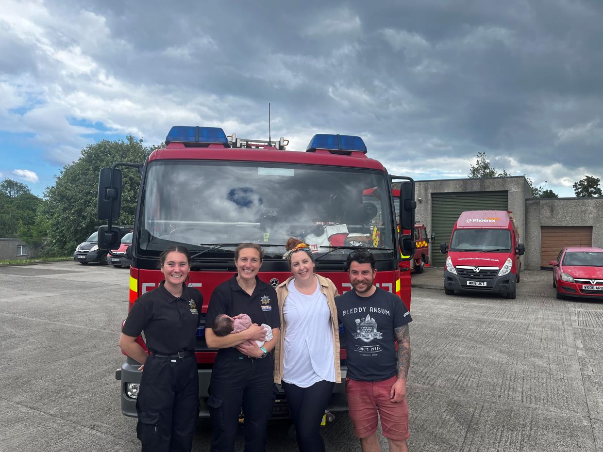 Baby Olive with her parents and the fire fighters who helped deliver her (Cornwall Council/PA)