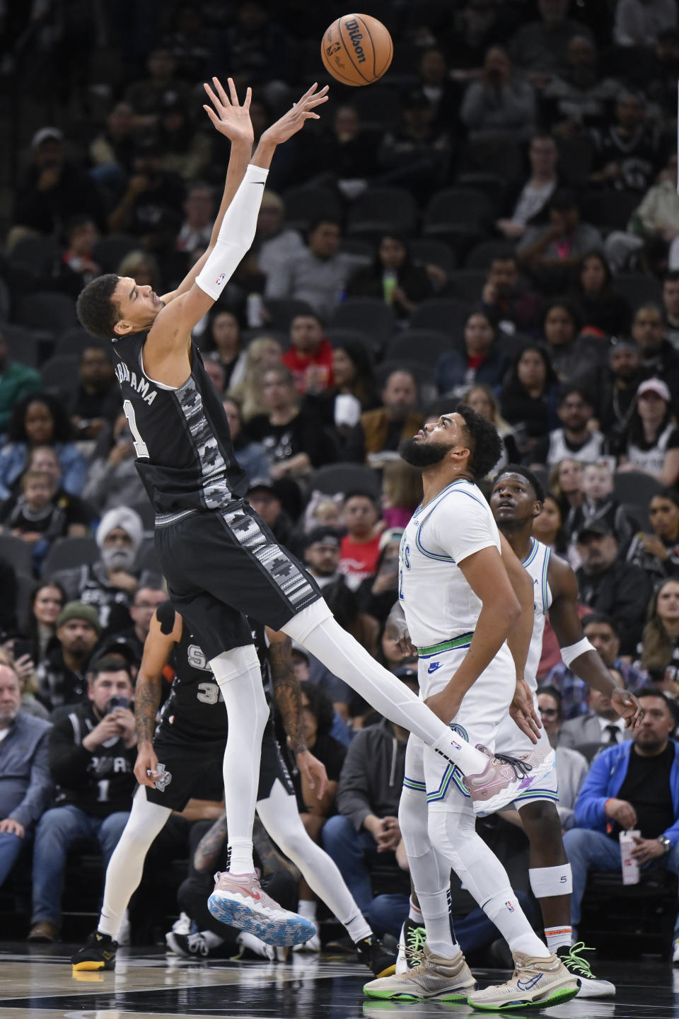 San Antonio Spurs' Victor Wembanyama, left, is fouled as he goes to the basket against Minnesota Timberwolves' Karl-Anthony Towns during the first half of an NBA basketball game Saturday, Jan. 27, 2024, in San Antonio. (AP Photo/Darren Abate)
