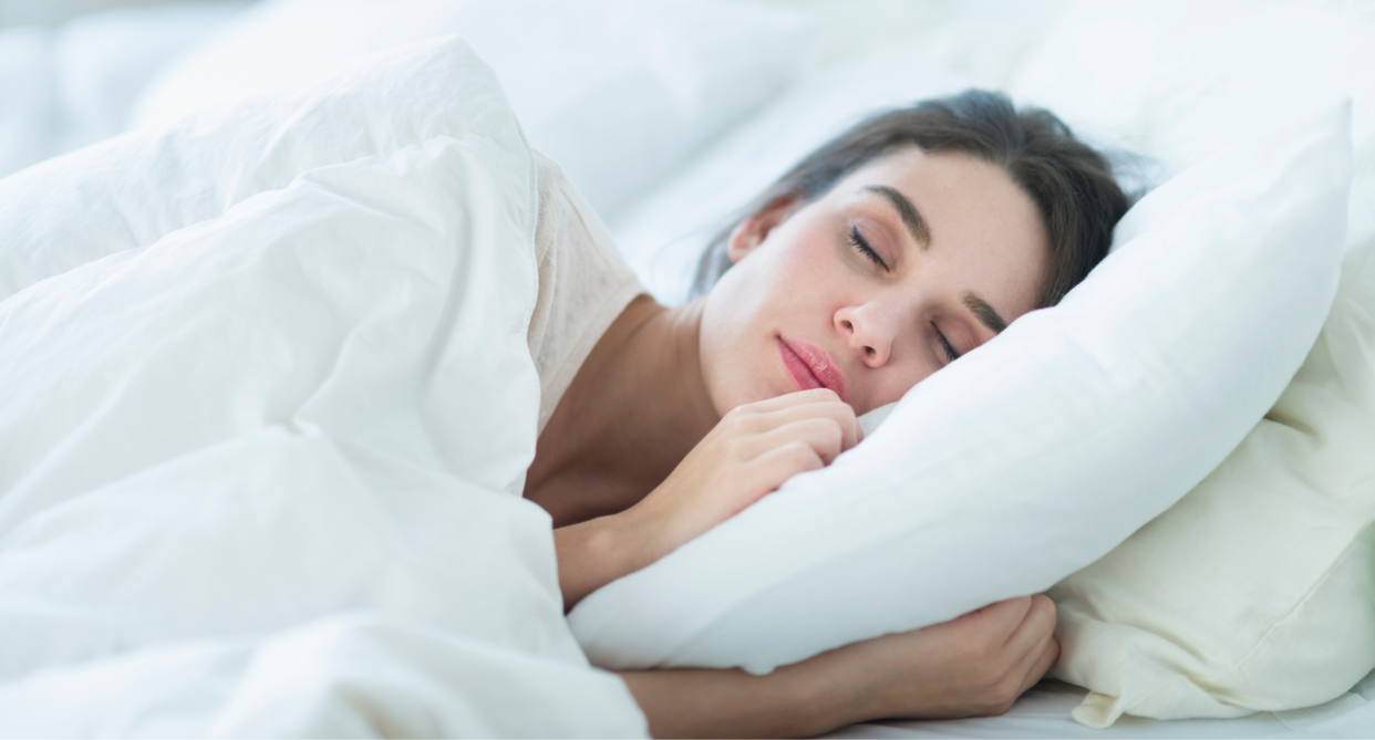 woman sleeping in white sheets and bedding 