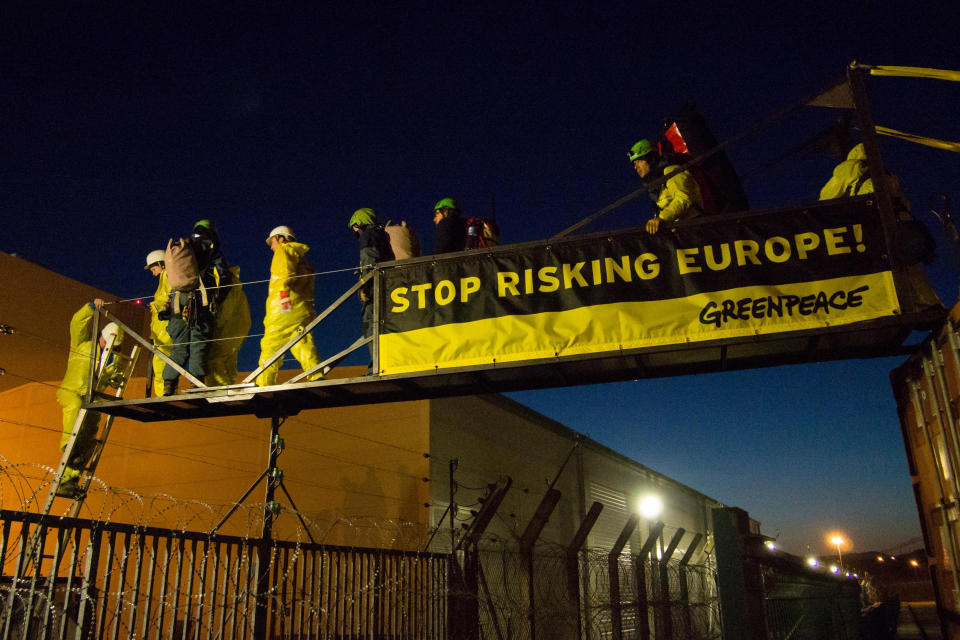 In this photo provided by environmental group Greenpeace, activisits hang a banner reading "Stop Risking Europe" next to one of the reactors at the Fessenheim nuclear power plant, eastern France, Tuesday, March 18, 2014. More than 60 Greenpeace activists have occupied a nuclear plant in eastern France to protest the nation's reliance on atomic power. In a statement Greenpeace France said the activists had come from 14 countries across Europe "to denounce the risk to Europe from France's nuclear power," and to promote a transition to other energy sources. (AP Photo/Greenpeace, Bente Stachowske)