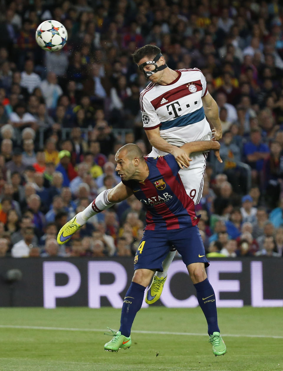 Football: Bayern Munich's Robert Lewandowski heads at goal under pressure from Barcelona's Javier Mascherano