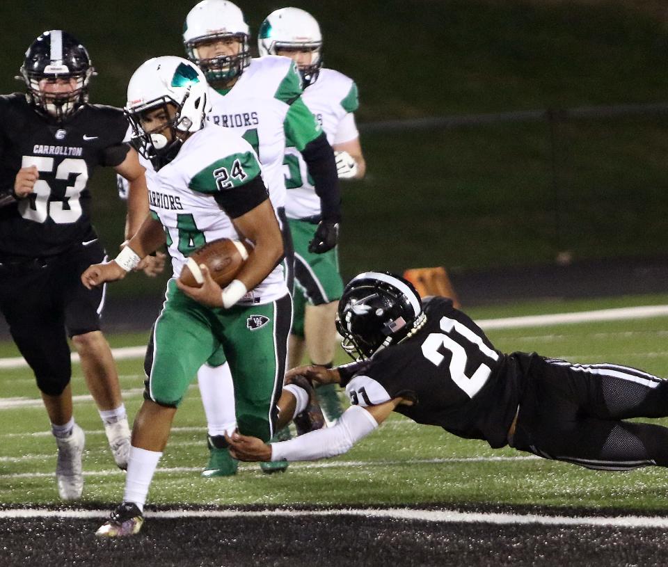 West Branch's Alek Wilson (24) on a long second quarter run as Carrollton's Domanick Speelman (21) tries to tackle during conference action at Carrollton on Friday, September 18, 2020.