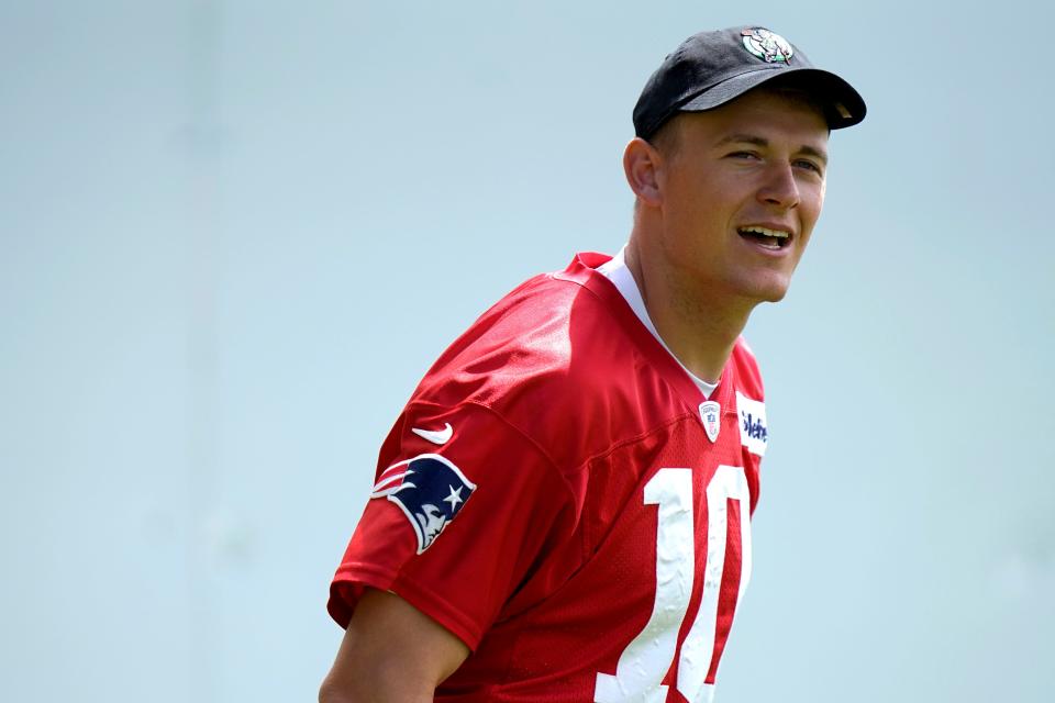 New England Patriots quarterback Mac Jones, donning a Boston Celtics cap, steps on the field before the start of OTA's in Foxboro on Monday.