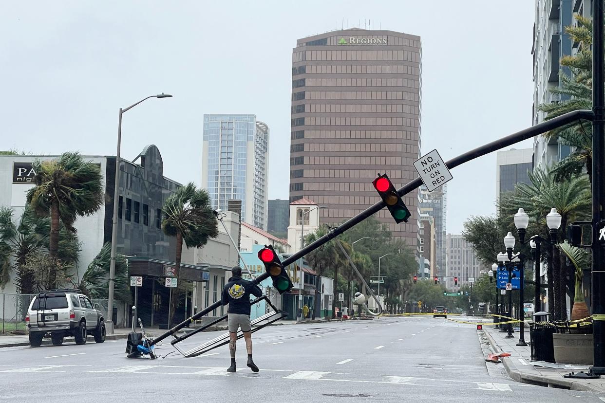 A man stands in the middle of an empty street near a downed traffic light in Orlando.