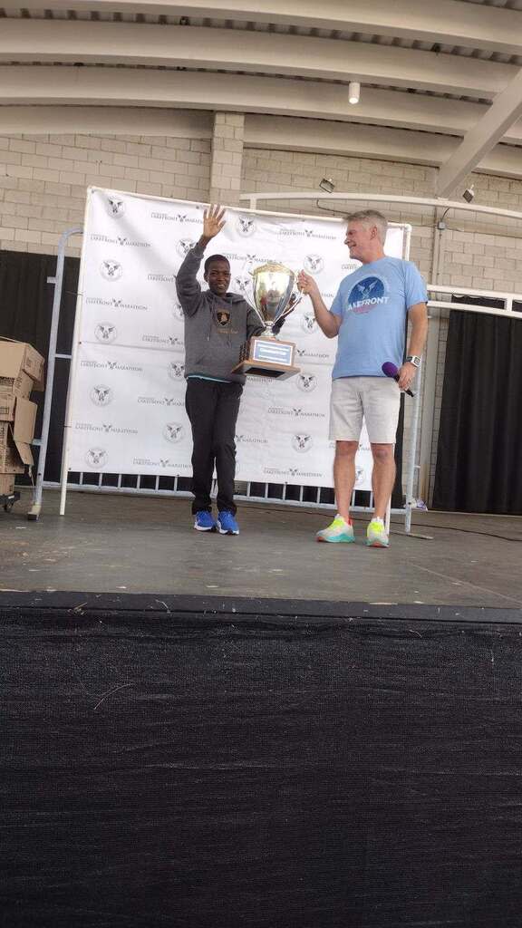 Damaris Areba is honored as the female winner of the Milwaukee Lakefront Marathon by race director Scott Stauske several hours after the race ended.