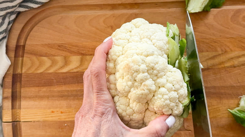 hand slicing cauliflower stem