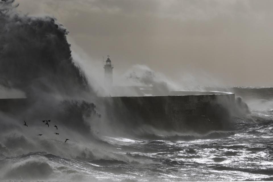 Waves crash against a lighthouse during storms that battered Britain and where a 14-year-old boy was swept away to sea at Newhaven in South East England October 28, 2013. Britain's strongest storm in a decade battered southern regions on Monday, forcing hundreds of flight cancellations, cutting power lines and disrupting the travel plans of millions of commuters. Police said rescuers were forced to call off a search for the boy late on Sunday due to the pounding waves, whipped up by the rising wind. (REUTERS/Luke MacGregor)