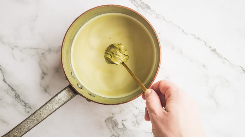 adding pistachio cream to saucepan