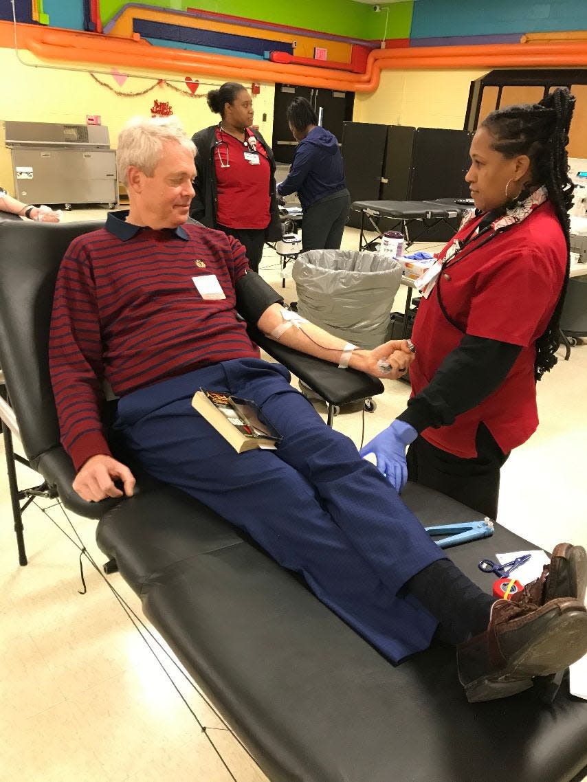 Shawn Siddall of Monroe donates a pint of blood during an American Red Cross blood drive held Monday afternoon at Custer Elementary School 1 in Monroe. Siddall, 53, has donated about 70 pints since he was 21. He has O-positive blood and also has donated several Power Red units of red blood cells. Assisting him is Alisha Caffey, a phlebotomist for the Toledo Chapter of the Red Cross.