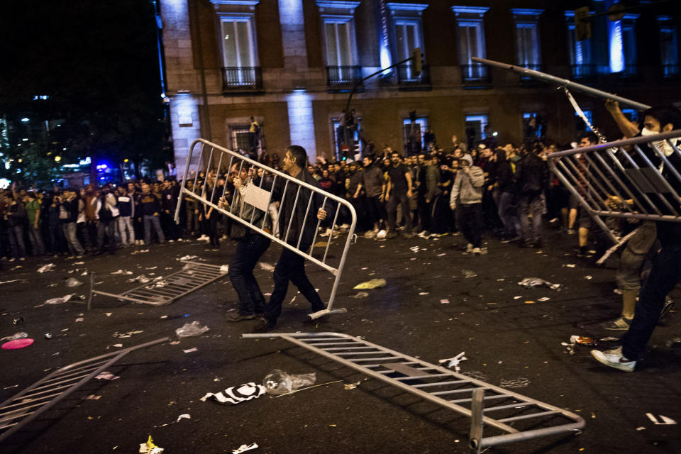 Demonstrators throw fences during riots after a march to the Spanish Parliament against the austerity measures announced by the Spanish government in Madrid, Spain, Tuesday, Sept. 25, 2012. Spain's government was hit hard by the country's financial crisis on multiple fronts Tuesday as protestors enraged with austerity cutbacks and tax hikes clashed with police near Parliament, a separatist-minded region set elections seen as an independence referendum and the nation's high borrowing costs rose again. (AP Photo/Daniel Ochoa De Olza)