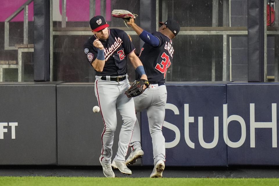 Washington Nationals' Lane Thomas, left, tries to avoid a collision with left fielder Stone Garrett, who loses control of a ball hit by New York Yankees' Kyle Higashioka during the second inning of a baseball game Wednesday, Aug. 23, 2023, in New York. Higashioka reached first base on the error by Garrett. (AP Photo/Frank Franklin II)