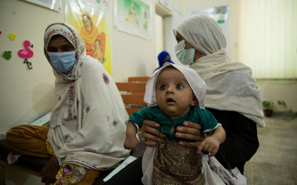 Four-month-old Zara Bibi waits for a check at a stunting clinic - Saiyna Bashir
