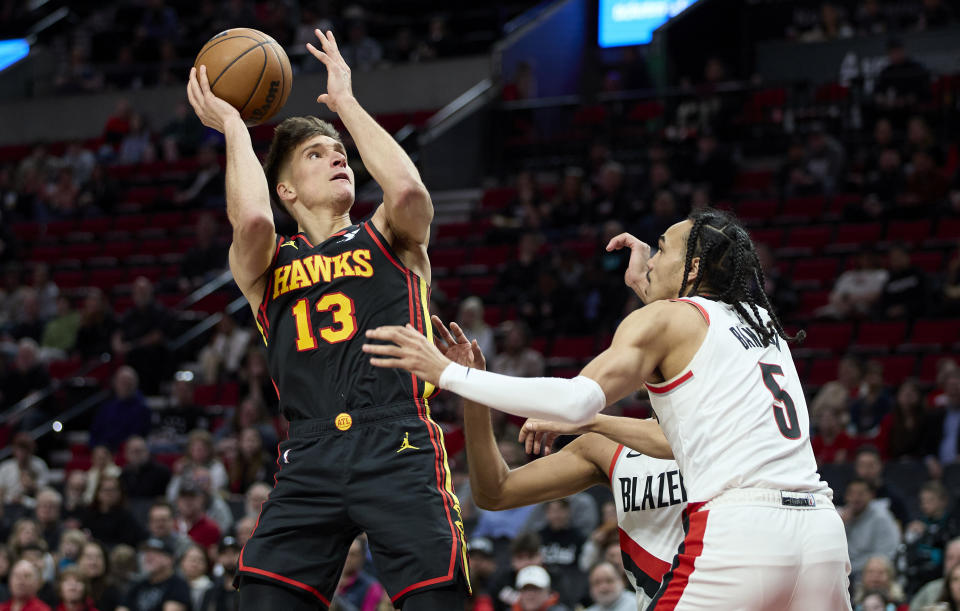 Atlanta Hawks guard Bogdan Bogdanovic, left, shoots over Portland Trail Blazers guard Dalano Banton during the first half of an NBA basketball game in Portland, Ore., Wednesday, March 13, 2024. (AP Photo/Craig Mitchelldyer)