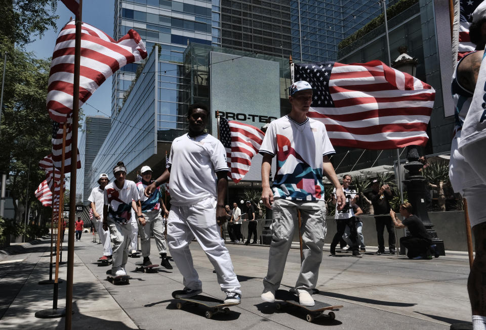 Members of the first U.S. Olympic skateboarding team arrive on their boards for a news conference in downtown Los Angeles on Monday, June 21, 2021. The team was introduced in Southern California, where the sport was invented roughly 70 years ago. Skateboarding is an Olympic sport for the first time in Tokyo, and the Americans are expected to be a strong team. (AP Photo/Richard Vogel)